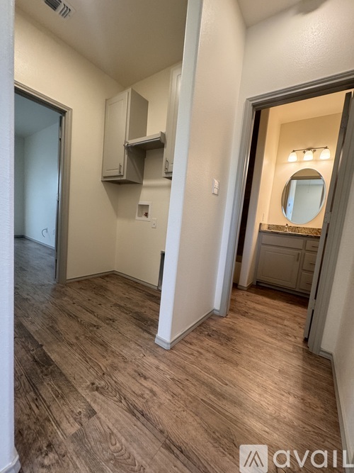 A room with wood flooring and a mirror on the wall.