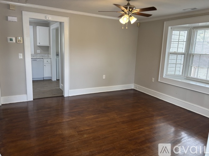 A room with a ceiling fan and wooden floors.