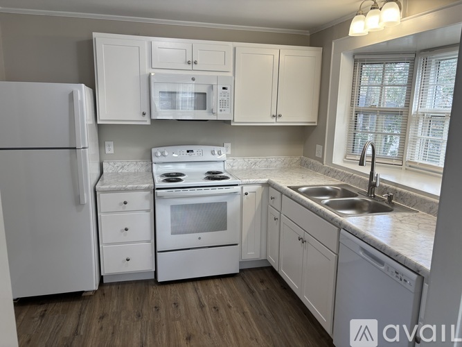 A kitchen with white appliances and cabinets.