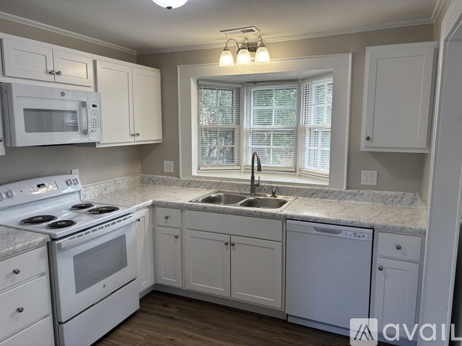 A kitchen with white appliances and cabinets.