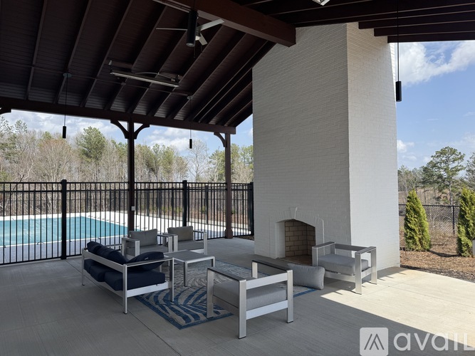 A patio with a pool and a fireplace.