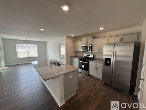 A kitchen with a granite countertop and stainless steel appliances.