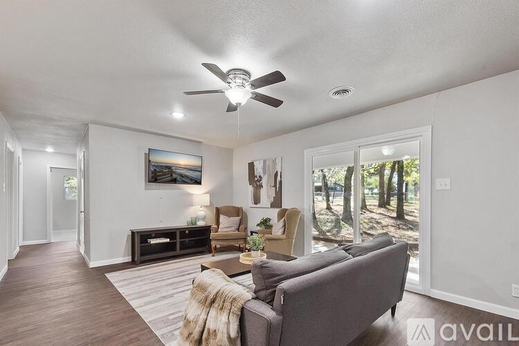 A living room with a grey couch and a ceiling fan.