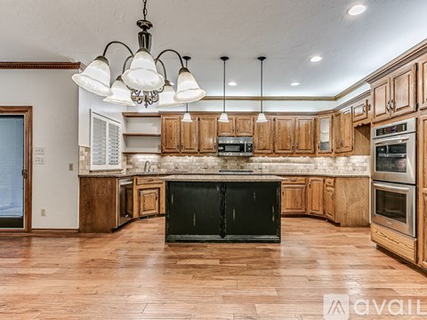A kitchen with wooden cabinets and a black stove top oven.