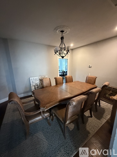 A dining room with a large table and chairs.