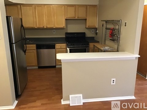 A kitchen with wooden cabinets and a refrigerator.