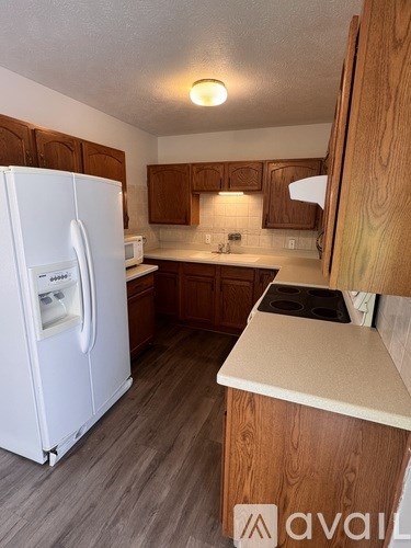 A kitchen with a white fridge and wooden cabinets.