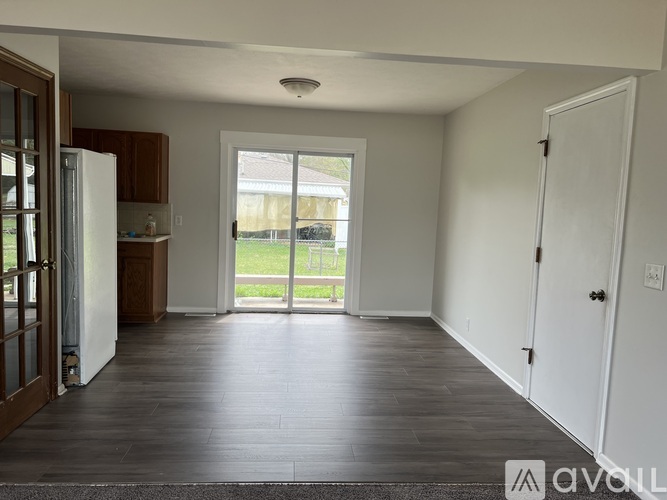 A living room with a sliding glass door leading to a backyard.