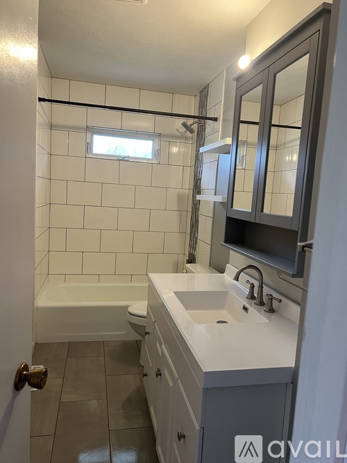 A bathroom with a white sink and a white bathtub.