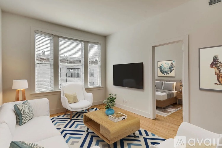 A living room with a white couch, a wooden coffee table, and a flat-screen TV.