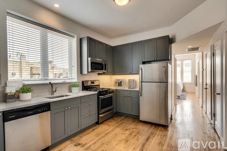 A kitchen with wooden floors and stainless steel appliances.