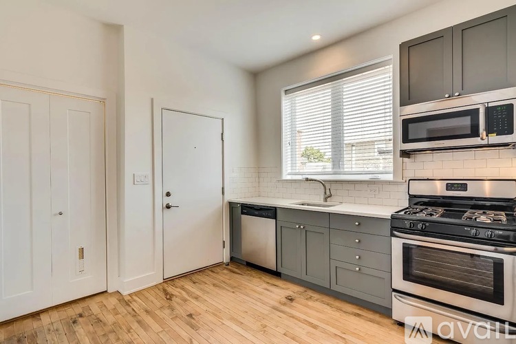 A kitchen with wooden floors and white walls.