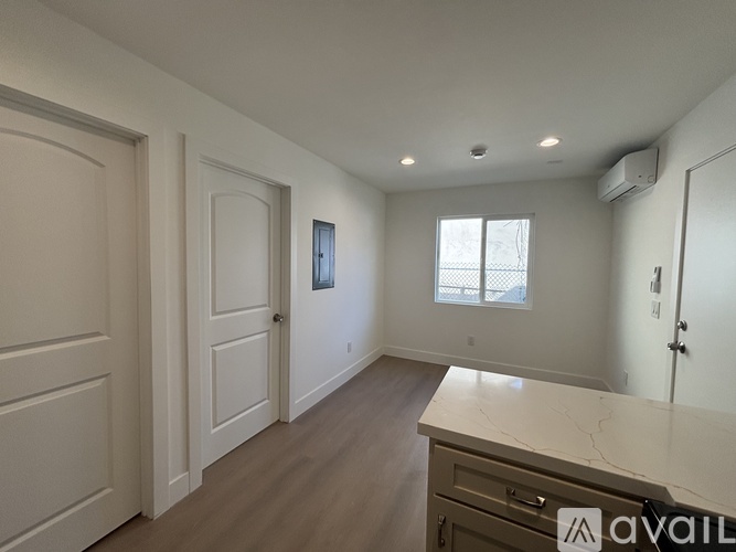 A spacious room with a marble countertop and wooden flooring.