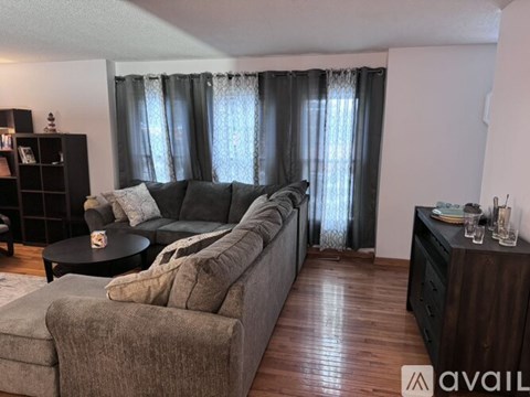 A living room with a grey couch and a black coffee table.