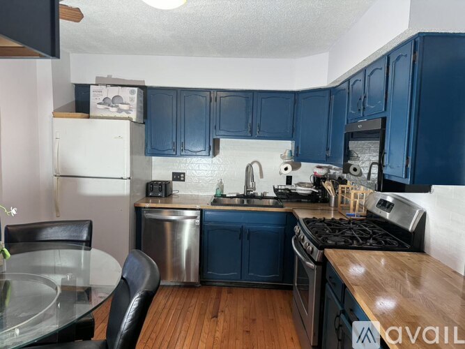 A kitchen with blue cabinets and a white fridge.