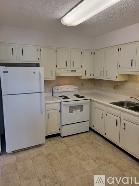 A kitchen with white appliances and cabinets.
