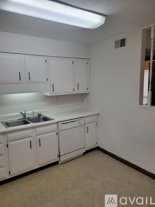 A kitchen with white cabinets and a sink.