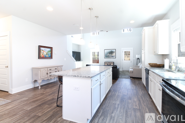 A kitchen with white cabinets and a marble countertop.