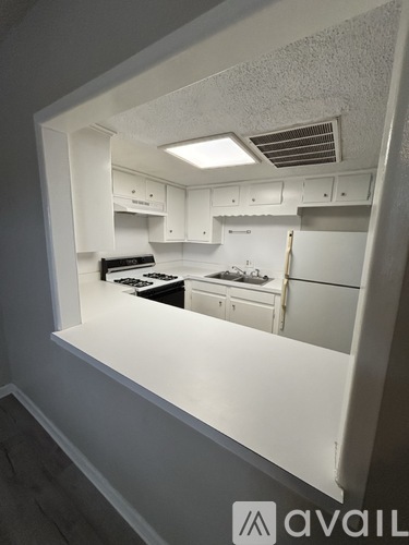 A kitchen with white cabinets and appliances.