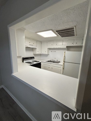 A kitchen with white cabinets and appliances.