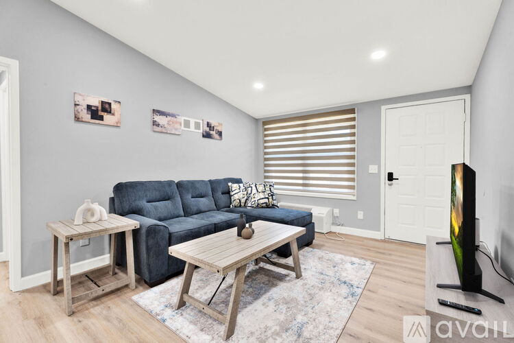 A living room with a blue couch, a wooden coffee table, and a flat screen TV.