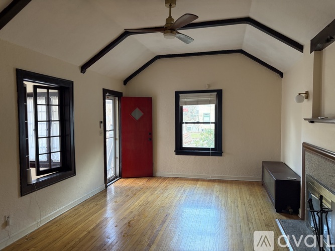 A room with a red door and a ceiling fan.