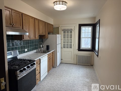 A kitchen with a black stove top oven and white appliances.
