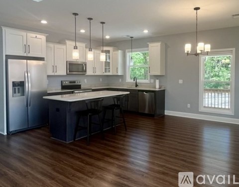 A modern kitchen with a center island and pendant lights.