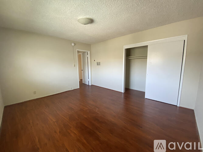 A room with wooden floors and two doors.