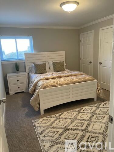 A bedroom with a large bed and a window.