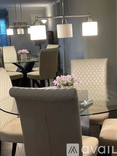 A modern dining room with a glass table and chairs.