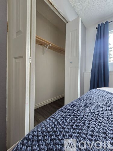 A bedroom with a bed and a closet.
