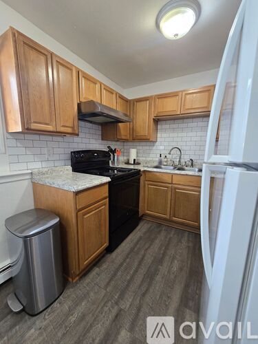 A kitchen with wooden cabinets and a black stove top oven.