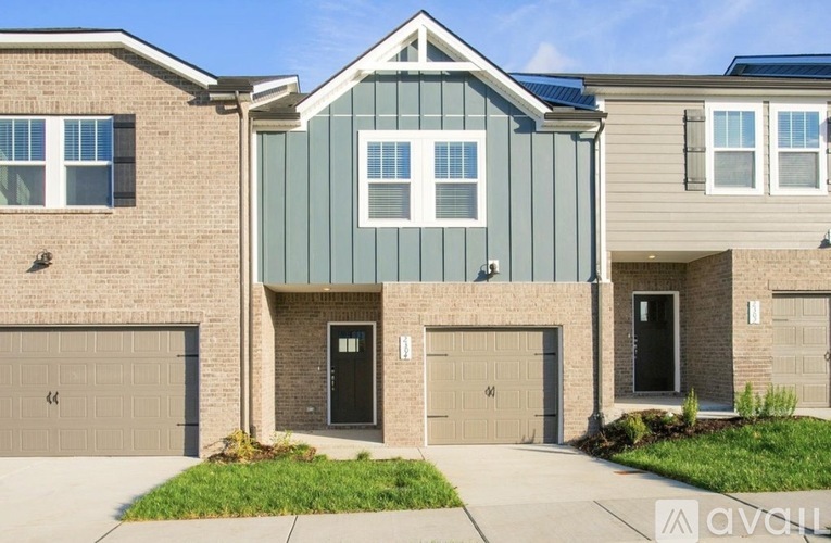 A modern two-story house with a garage on the first floor and a balcony on the second floor.