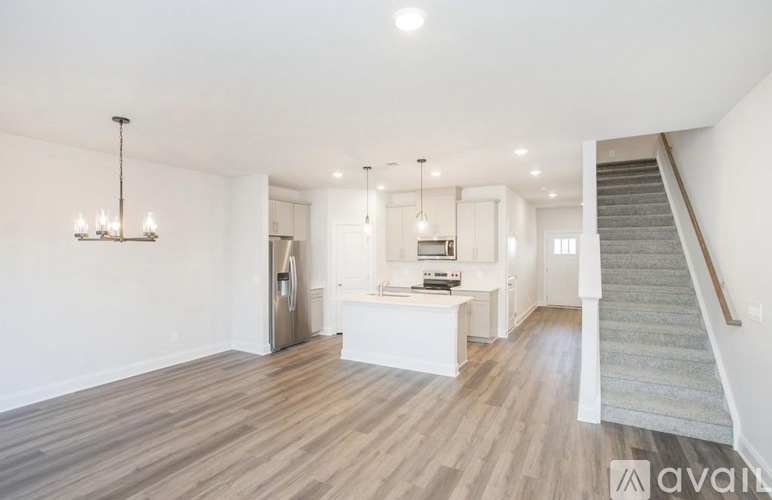 A spacious living room with a staircase on the right side.