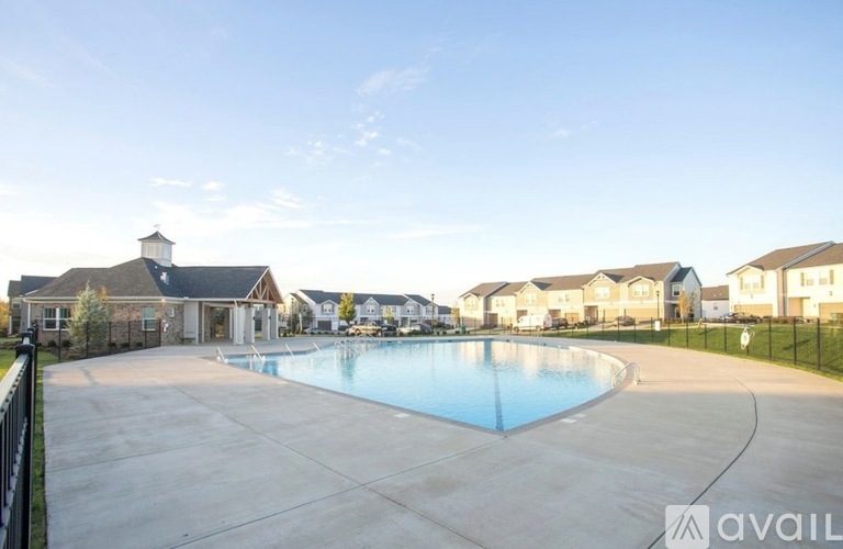 A large swimming pool in a residential area with houses in the background.