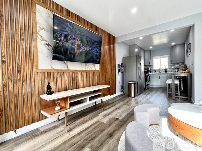 A modern living room with a wooden wall and a large painting.