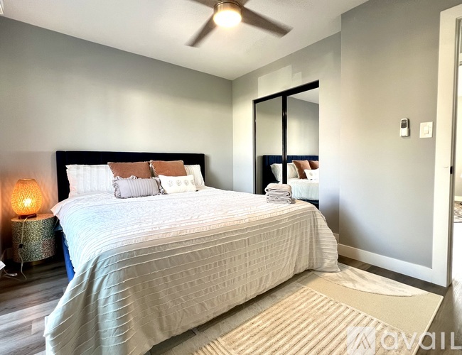 A bedroom with a large bed and a ceiling fan.