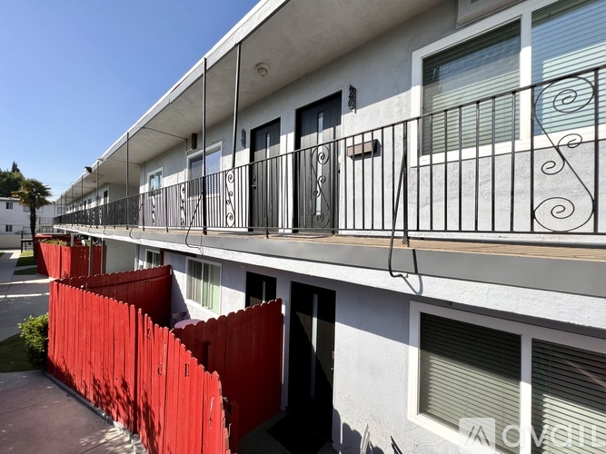 A white building with a red fence in front.