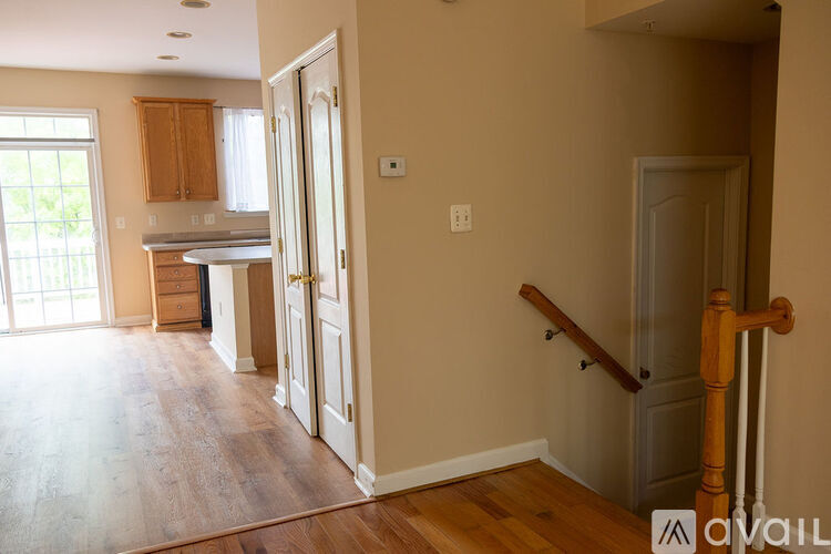A room with wooden floors and a staircase leading to another room.
