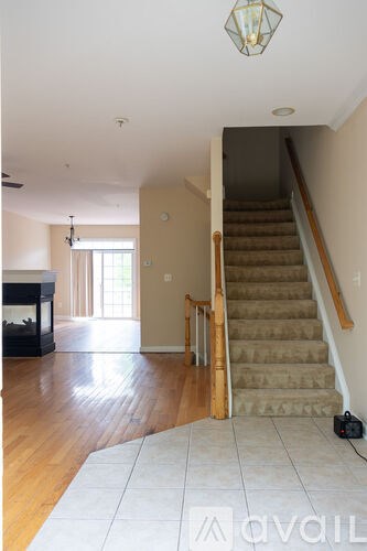 A living room with a staircase leading to the second floor.