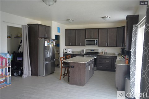 A kitchen with brown cabinets and a refrigerator.