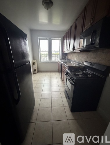 A kitchen with black appliances and brown cabinets.