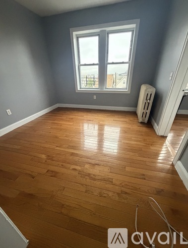 A room with wooden flooring and a window.