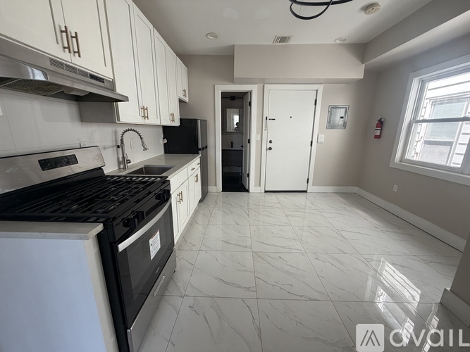 A kitchen with black appliances and white cabinets.