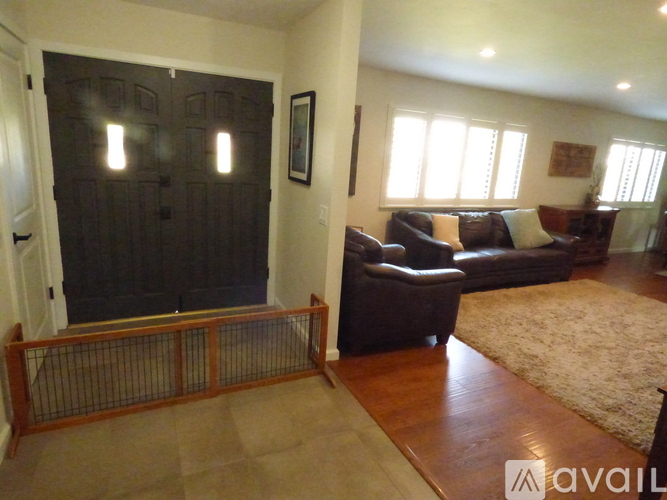 A living room with a dark brown fireplace and brown leather couches.