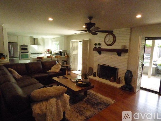 A living room with a brown couch and a fireplace.