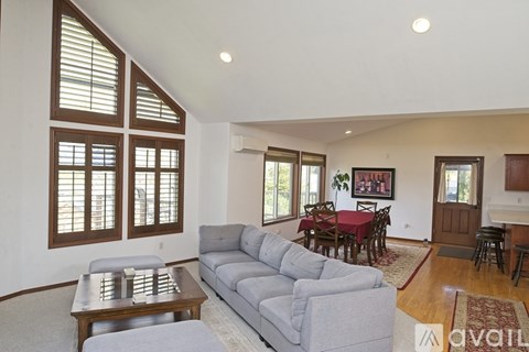 A living room with a grey couch and a wooden coffee table.