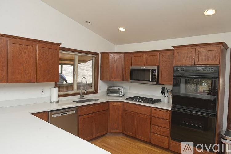A kitchen with wooden cabinets and black appliances.