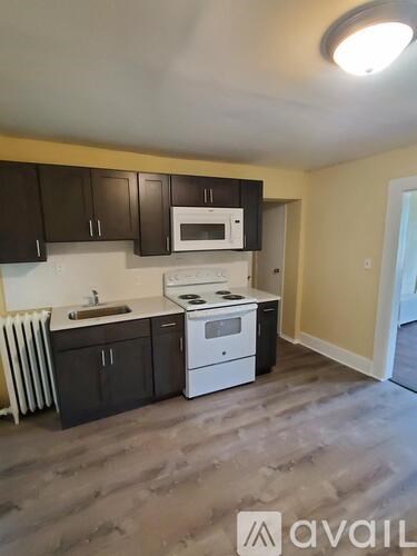 A kitchen with a white stove top oven and microwave above it.